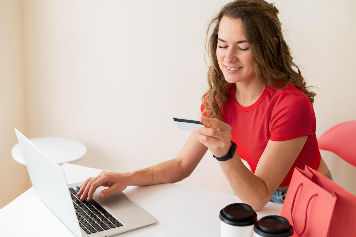 Voorbereiding online transactie: meisje overweegt pinpas met laptop op bureau"